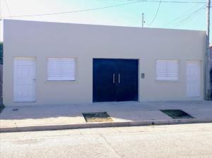 a white building with two doors and two windows at Zona Sur Apart in Salta