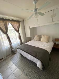 a bedroom with a bed and a ceiling fan at HomeSweetHome City Apartment in Nelspruit