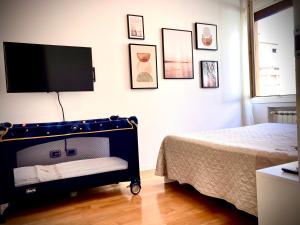 a bedroom with a bed and a flat screen tv at TulipHouse da Davide in Bologna