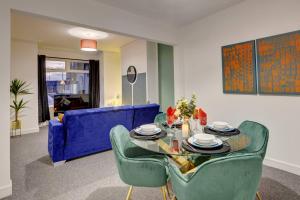 een woonkamer met een tafel en een blauwe bank bij Stunning 3 bed House in Central Hull in Hull