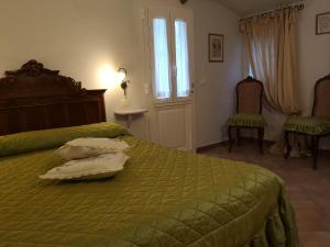 1 dormitorio con 1 cama verde y 2 almohadas en Tenuta Agriturismo IL RISVEGLIO, en Imperia