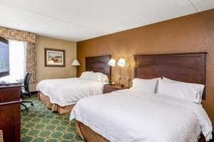 a hotel room with two beds and a desk at Wingate by Wyndham Baltimore BWI Airport in Baltimore