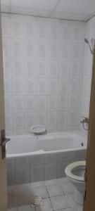 een badkamer met een wit bad en een toilet bij Holiday Home 2 Bedrooms Apartment for Family Only in Sharjah