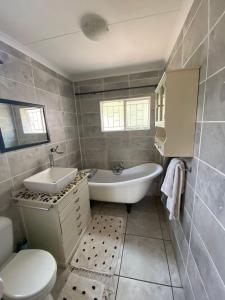 a bathroom with a tub and a sink and a toilet at HomeSweetHome City Apartment in Nelspruit