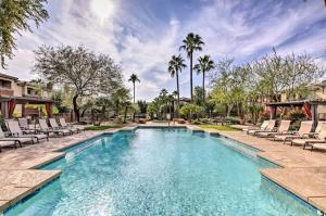 uma piscina com espreguiçadeiras e palmeiras em Central Phoenix Condo - Walk to Papago Park! em Phoenix