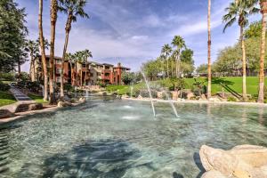 a pool with a fountain in a yard with palm trees at Walk to Papago Park Central Phoenix Condo in Phoenix