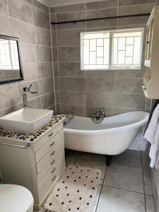 a bathroom with a tub and a sink and a toilet at HomeSweetHome City Apartment in Nelspruit