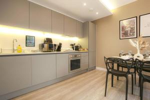 a kitchen and dining room with a table and chairs at Luxury Apartment - Close to City Centre - Free Parking, Fast Wifi, SmartTV with Sky and Netflix by Yoko Property in Milton Keynes