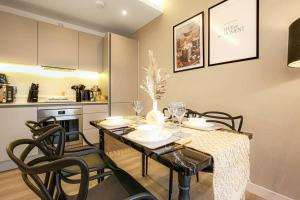a dining room with a table and chairs in a kitchen at Luxury Apartment - Close to City Centre - Free Parking, Fast Wifi, SmartTV with Sky and Netflix by Yoko Property in Milton Keynes