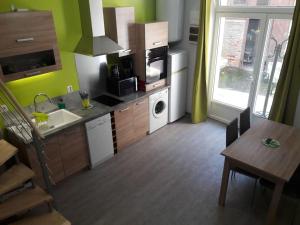 una cucina con lavandino e tavolo con sala da pranzo di appartement tranquille a Rochechouart