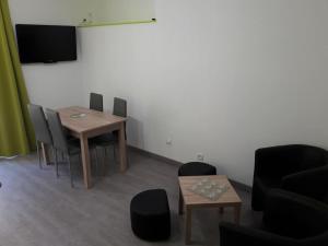 una camera con tavolo, sedie e televisore di appartement tranquille a Rochechouart