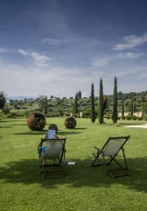 duas pessoas sentadas em cadeiras num campo de relva em Delser Verona Manor House em Verona