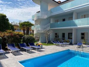 ビビオーネにあるApartments in Bibione 36154のプールと椅子と建物のあるリゾート
