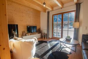 恩吉尔波登Tauerndorf Enzingerboden Ski in&out - Steinbock Lodges的客厅里有一张沙发和一张桌子。