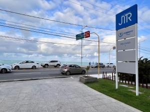 a sign for a car dealership in a parking lot at Apartamento JTR Cond Beira Mar - Castelo B Temporada in Maceió