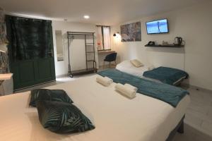 a bedroom with two beds and a green door at Hotel De La Crois&eacute;e in Poncin