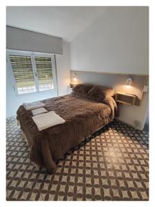 a bedroom with a large bed with a brown blanket at CASA TRANSFORMER in Córdoba