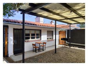 a patio with a table and chairs in front of a house at CASA TRANSFORMER in Córdoba