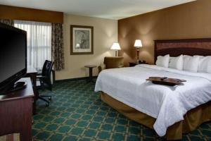 a hotel room with a large bed and a flat screen tv at Wingate by Wyndham Baltimore BWI Airport in Baltimore