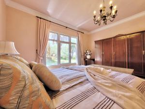 1 dormitorio con 1 cama grande, lámpara de araña y ventana en Casa Irlanda Deluxe Apartment, en San Marcos