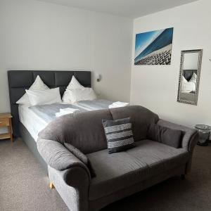 un soggiorno con divano e letto di Hotel & Restaurant Blume a Wolfsburg