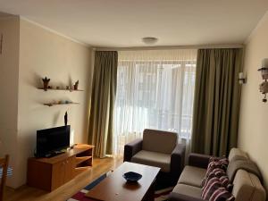 a living room with a couch and a tv at 2 bedroom apartment near Gondola in Bansko