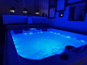 een hot tub in een kamer met blauwe verlichting bij Relax nella jacuzzi in Toscana in Colle di Val d'Elsa