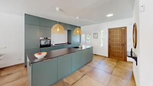 a kitchen with blue cabinets and a counter top at El Chaparral - Renovated Villa in La Cala in Mijas Costa