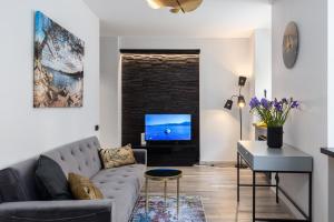 a living room with a couch and a tv at Moderns un kluss dzīvoklis 41 m2 in Rīga