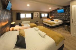 a hotel room with two beds and a desk at Hotel De La Crois&eacute;e in Poncin