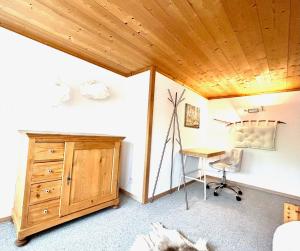 a bedroom with a desk and a wooden ceiling at Wunderschöne Maisonette-Ferienwohnung in stattlichem Toggenburgerhaus in Sankt Peterzell