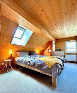 - une chambre avec un grand lit au plafond en bois dans l'établissement Wunderschöne Maisonette-Ferienwohnung in stattlichem Toggenburgerhaus, à Sankt Peterzell