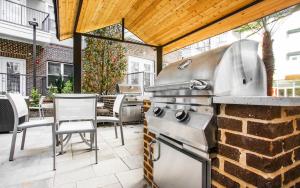 a patio with a grill and a table and chairs at Premium Apartments and Studios at Midtown 205 in Charlotte in Charlotte