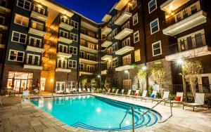 a swimming pool in front of a building at night at Premium Apartments and Studios at Midtown 205 in Charlotte in Charlotte