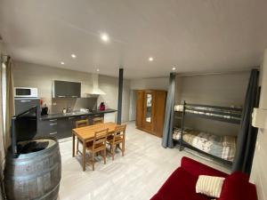 a living room with a kitchen and a table with a couch at Cauterets Charmant Studio 4 personnes in Cauterets