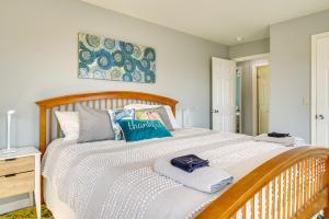 a bedroom with a wooden bed with towels on it at The 1818 Home with Porch and Grill - 1 Mi to Beach! in Lake Como