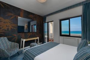 a bedroom with a bed and a view of the ocean at Hotel Oasi Di Kufra in Sabaudia