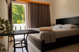 a bedroom with a bed and a table and a window at Casa Tacuba in Puerto Escondido +89 photos