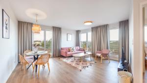 a living room with a couch and a table and chairs at Apartamenty Sun & Snow Residence I Jastrzębia Góra in Jastrzębia Góra