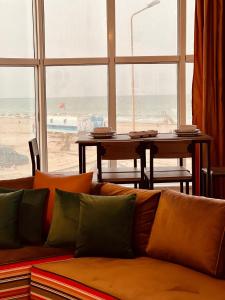 a couch in a living room with a view of the beach at Appartement Vue de Mer Pied dans l'eau in Gabès