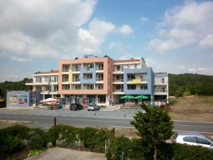 a building on the side of a road with a parking lot at Hotel Marant in Sozopol