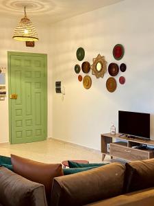 a living room with a couch and a green door at Appartement Vue de Mer Pied dans l'eau in Gabès