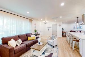 sala de estar con sofá marrón y cocina en Largo Luxury, en Largo