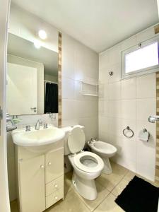 a white bathroom with a toilet and a sink at Hermoso departamento Godoy Cruz in Godoy Cruz