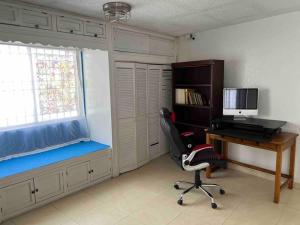Zimmer mit einem Schreibtisch, einem Stuhl und einem Computer in der Unterkunft Casa completa de 3 cuartos en una zona tranquila. in Ciudad Juárez