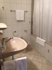un baño con lavabo y ducha en Hotel Belmont, en Crans-Montana 29 fotos más
