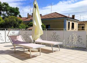 two chairs and an umbrella on a balcony at Villa Liberty B&B in Fano