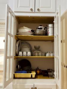 un armario de cocina lleno de ollas y sartenes en Appartement Vue de Mer Pied dans l'eau, en Gabès