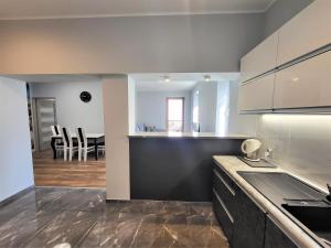 a kitchen with white cabinets and a dining room at Apartament Bryza Aquarius - z miejscem parkingowym in Ustka