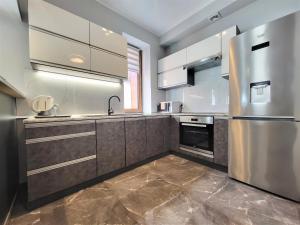 a kitchen with a stainless steel refrigerator and a sink at Apartament Bryza Aquarius - z miejscem parkingowym in Ustka